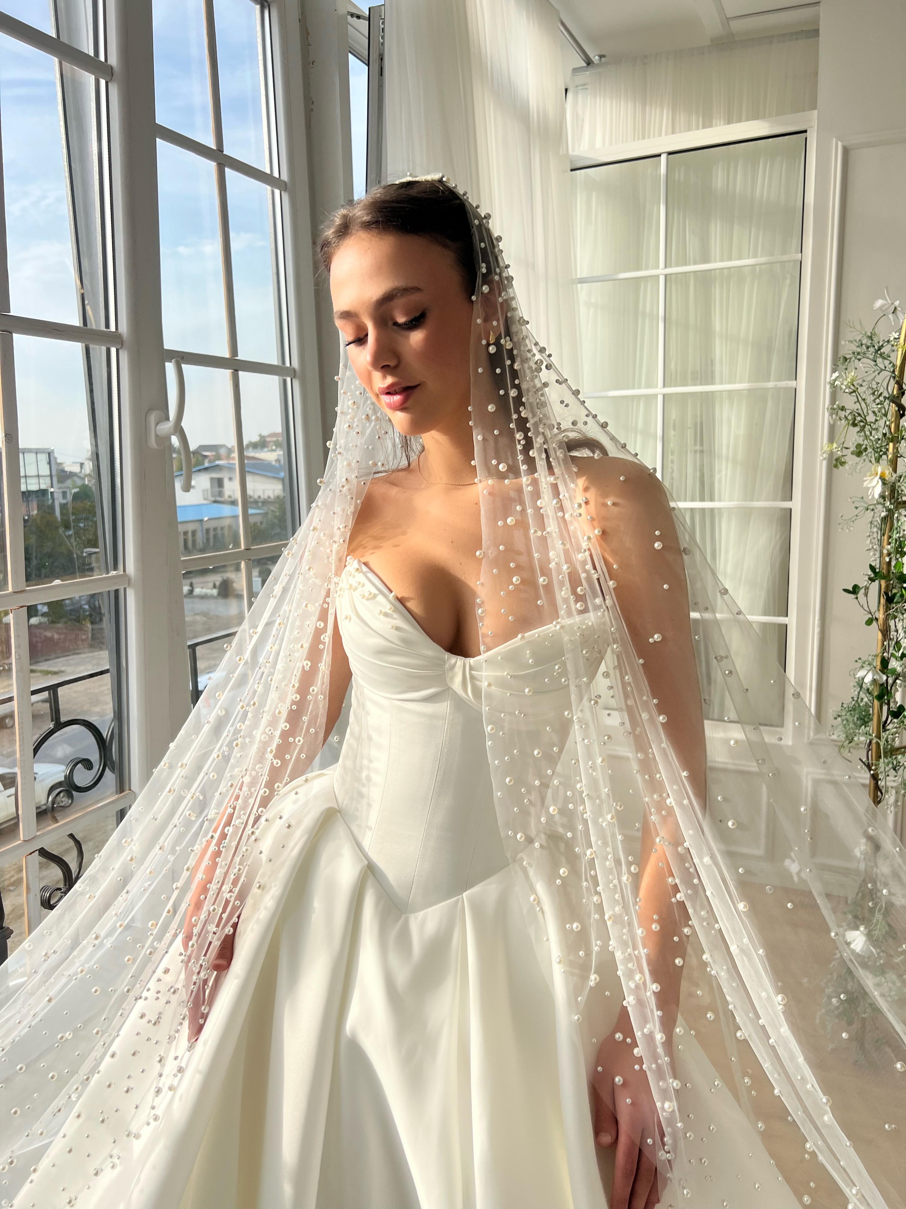 White bridal A-Line gown with beaded cape and no sleeves