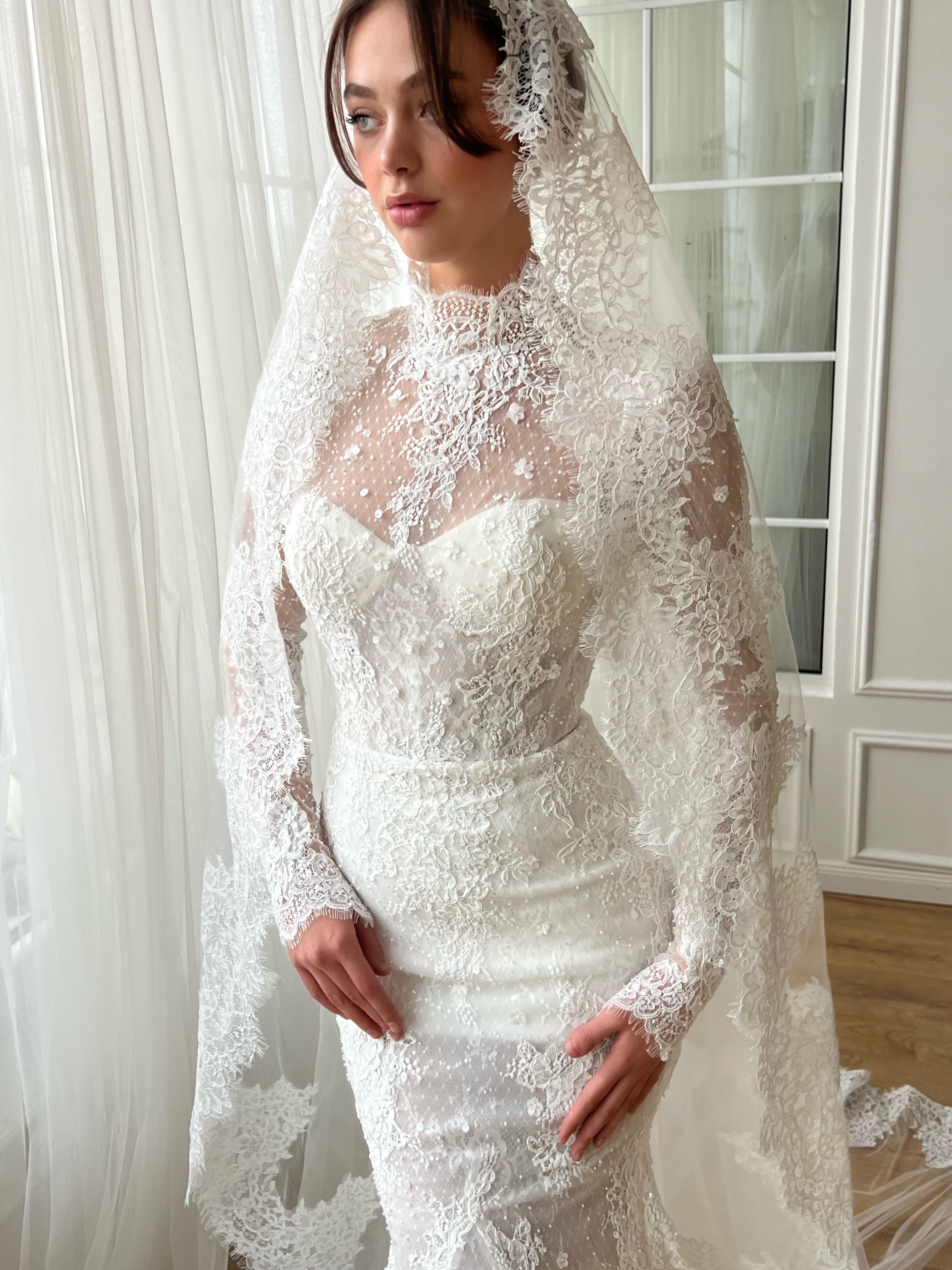 White bridal mermaid dress with long sleeves, lace, embroidery and veil