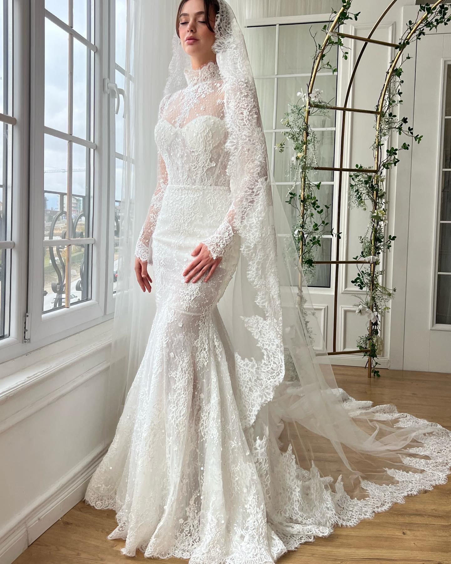 White bridal mermaid dress with long sleeves, lace, embroidery and veil