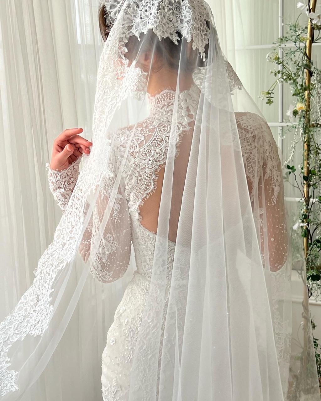 White bridal mermaid dress with long sleeves, lace, embroidery and veil